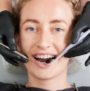 dentist examining woman teeth with braces